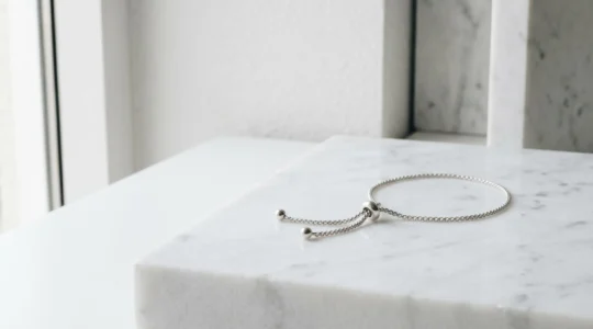 Pulsera ajustable de plata con cierre corredero sobre fondo minimalista con espacio negativo