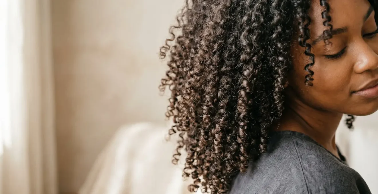 Rizos naturales tipo 3 y 4 con definición y brillo saludable, primer plano detallado
